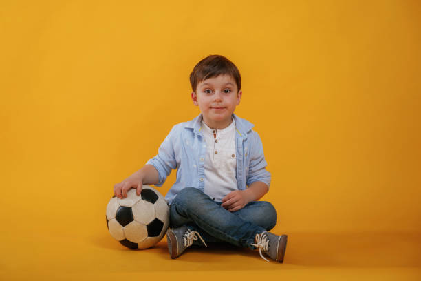 istock Front view. Little boy is in the studio against yellow background 2147718107