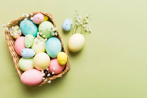 istock Happy Easter composition. Easter eggs in basket on colored table with gypsophila. Natural dyed colorful eggs background top view with copy space 2147718459