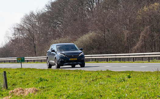 Netherlands, Overijssel, Twente, Wierden, March 19th 2023, side/front view close-up of a Dutch gray 2019 Peugeot 2nd generation 3008 MPV driving on the N36 at Wierden, the 3008 is made by French car manufacturer Peugeot since 2008, the N36 is a 36 kilometer long highway from Wierden to Ommen