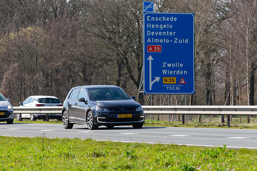 Netherlands, Overijssel, Twente, Wierden, March 19th 2023, side/front view close-up of a Dutch black 2015 hybrid Volkswagen 7th generation Golf station wagon driving on the N36 at Wierden, the Golf has been made by German manufacturer Volkswagen since 1974, the N36 is a 36 kilometer long highway from Wierden to Ommen