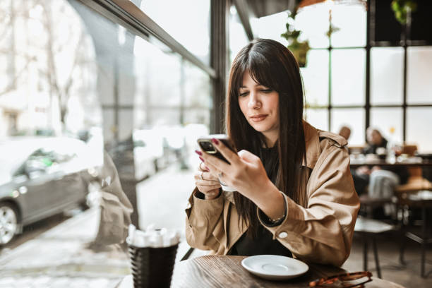 istock Female Focused On Texting Via Smartphone During Coffee Time 2147723149