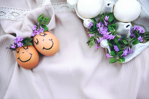 Easter painted Egg face with wild flowers decoration on cloth
