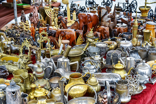 Set of silver, brass and copper utensils: jugs, teapots, bowls on flea market