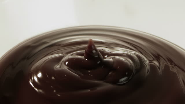 Liquid chocolate being poured cut out on white