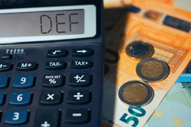 Calculator with banknotes with the word Def document of economy and finance of the government. Calculator with banknotes with the word Def document of economy and finance of the government. documento stock pictures, royalty-free photos & images