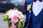 roses and peonies in a stylish wedding bouquet which the groom h