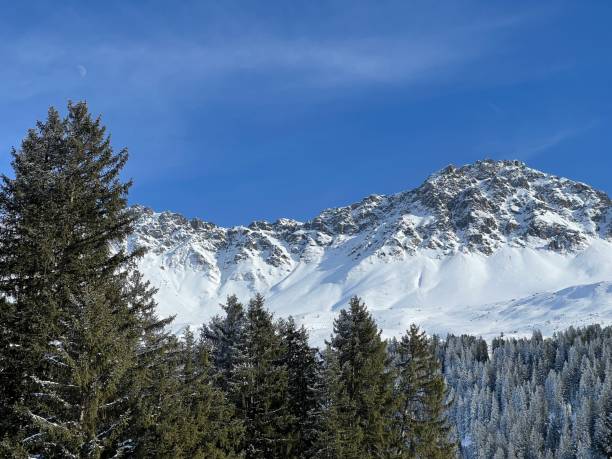 Beautiful sunlit and snow-capped alpine peaks above the Swiss tourist sports-recreational winter resorts of Valbella and Lenzerheide in the Swiss Alps - Canton of Grisons, Switzerland (Schweiz) stock photo