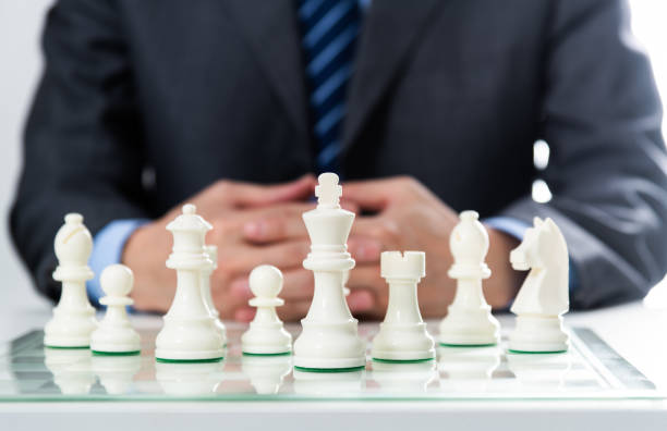 istock Businessman sitting in front of chess pieces 2148026173