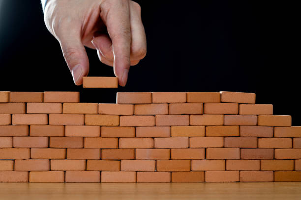istock Businessman putting toy brick onto a wall 2148026180