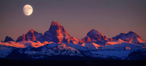 istock Sunset Light Alpen Glow on Tetons Teton Mountains wtih Moon Rising 2148026478