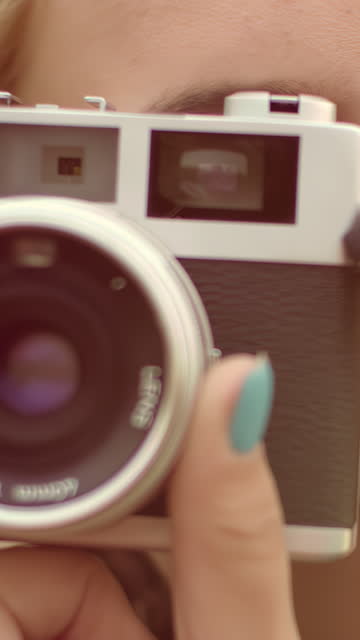 Young woman taking photo with retro camera