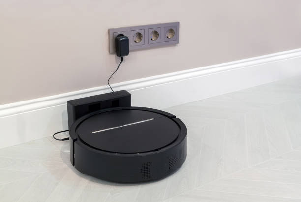 istock Robotic Vacuum Cleaner Charging Battery Smart Cleaning Technology. Modern smart electronic housekeeping technology 2148028614