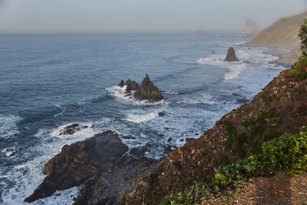 istock Dawn breaks over a tranquil coast with rocky cliffs and undulating waves, creating a peaceful seascape 2148029016