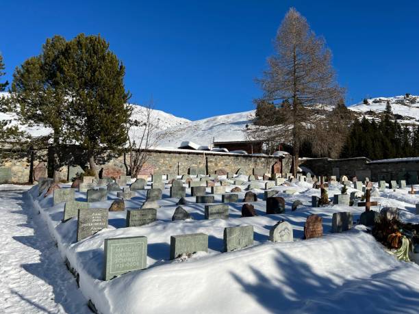 A miniature cemetery covered with fresh snow next to Arosa's mountain chapel (Das Bergkirchli Arosa) in the Swiss alpine winter resort Arosa - Canton of Grisons, Switzerland stock photo