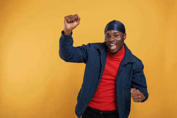 istock Having fun, celebrating success, hands up. Handsome black man is in the studio against yellow background 2148029254