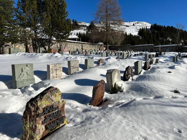 A miniature cemetery covered with fresh snow next to Arosa's mountain chapel (Das Bergkirchli Arosa) in the Swiss alpine winter resort Arosa - Canton of Grisons, Switzerland stock photo