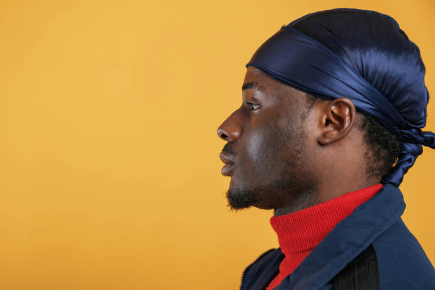 Man Covering Eyes with Beanie Hat in Low Light