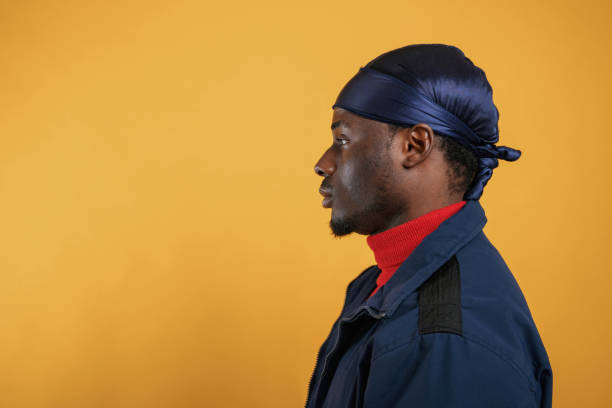 istock View from the side. Handsome black man is in the studio against yellow background 2148029302