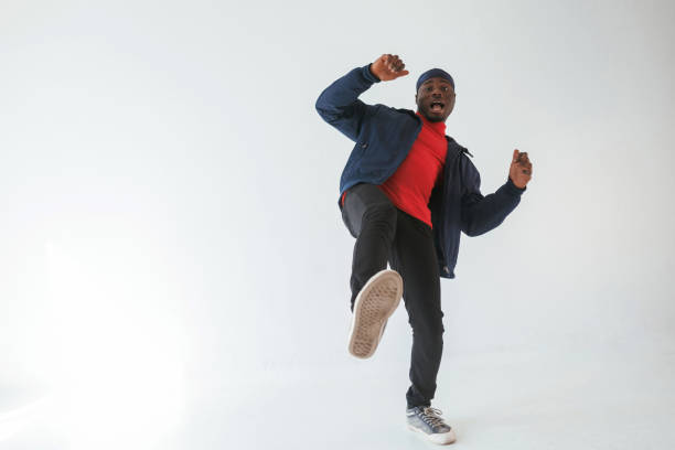 istock Showing thumbs up, having fun. Black man in cap is in the studio against white background 2148029989