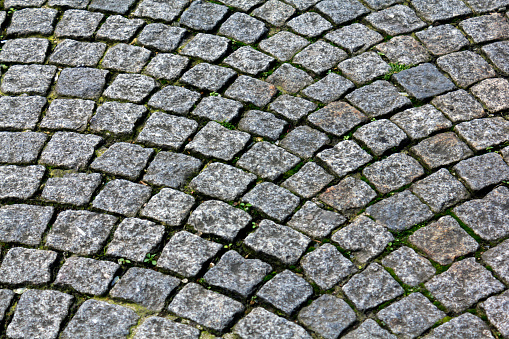 Road made with gray evenly cut stones.