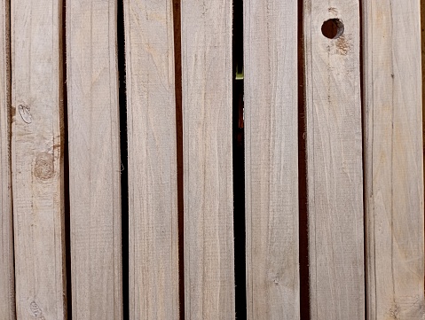 A wooden background made of boards that are loosely nailed to the wall with large gaps. Wooden wall