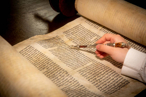 istock Young Female Hand with Yad Touching the Torah and Reading from the Hebrew Text 2148030559