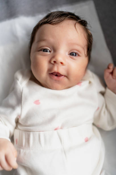 Smiling newborn baby in bed