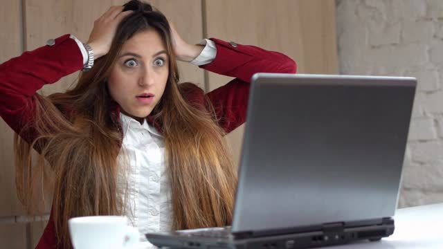 Young Woman Being Shocked By Something She Saw On Her Laptop
