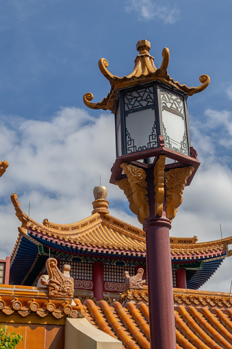 Lamp post in focus in front of Chinese Pagoda building at Epcot with blue sky and copy space