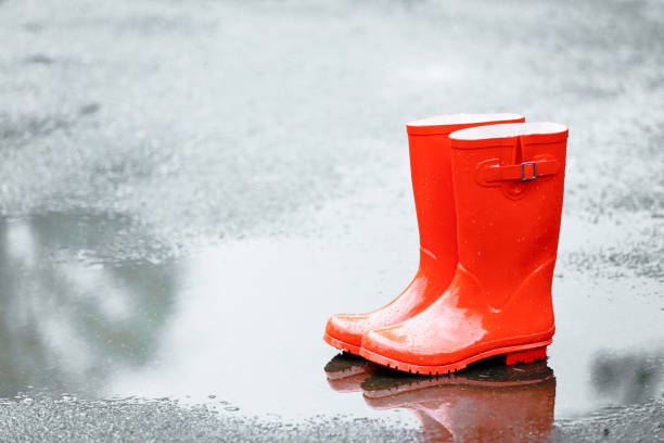 istock Red rubber boots in puddle after rain 2148032742