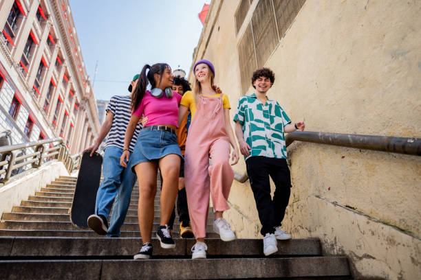 istock Young friends talking while walking down a staircase outdoors 2148033675