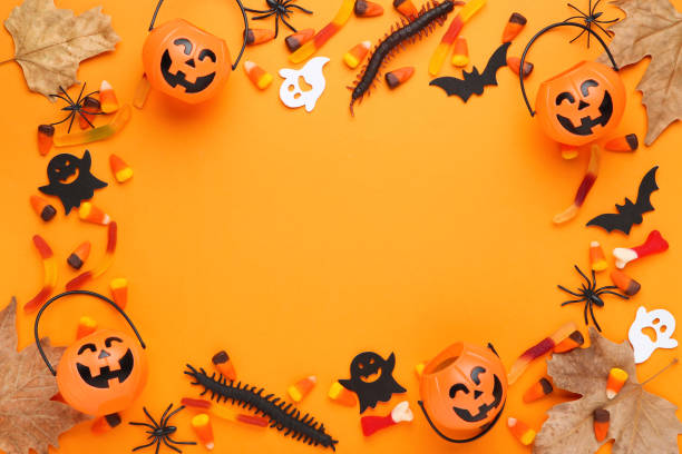 istock Halloween candies with pumpkin buckets and maple leafs on orange background 2148036308