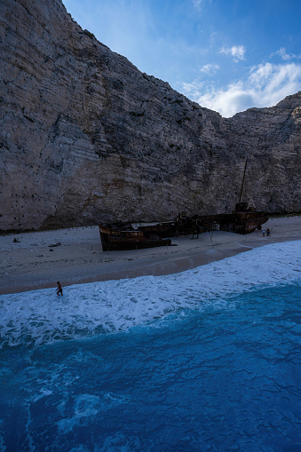 A beautiful view of a deserted beach with a sunken pirate ship washed ashore on a sunny summer day