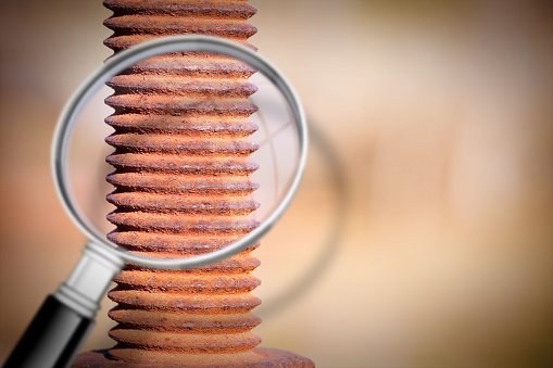 Control and surveillance of the conservation status of an old rusty metal structure - Detail of a nineteenth century structure seen through a magnifying glass - concept image