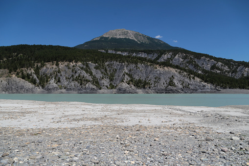 Drought at the Lac serre poncon reservoir in the french alps in the summer of 2022. The water is drained for the French Riviera.