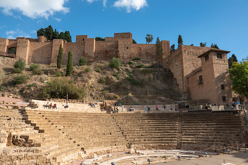 Malaga Andalusia Spain on November 4, 2023 Ruins of the old Roman theatre in the historic city centre. The Alcazaba in the mountain.