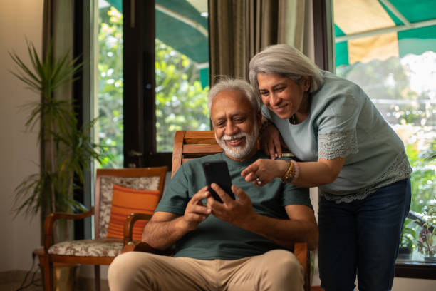 Senior couple using social media over cellphone at home