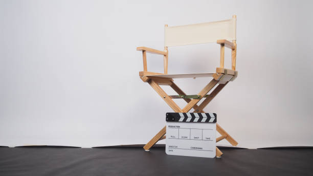 istock White director chair with clapper board on white background and black floor. 2148040753