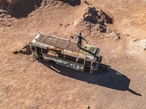 man standing on abandoned truck in vallecito valley in the Atacama desert