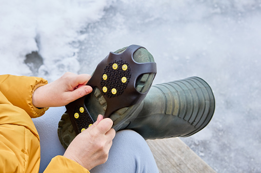 Spiked shoe overlay, spikes under ball and heel of foot provide traction on slippery surfaces, making it easier to walk on slippery ice or snow.
