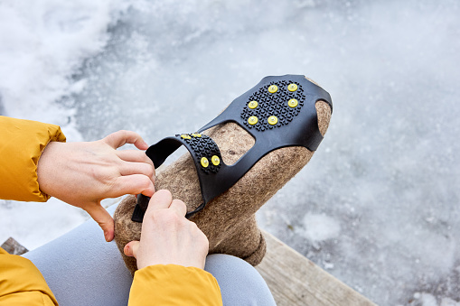 Use of studded overshoes on felted boots to improve traction on black ice.