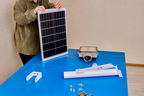 istock Bracket for mounting solar panel and LED  light of street lighting, user prepares for installation. 2148042560