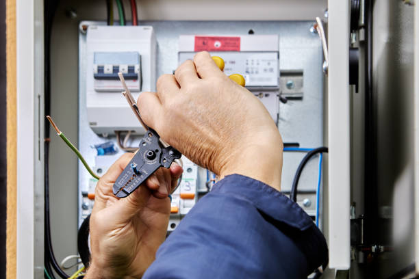 istock Electrical installation work on connecting power cable to an outdoor electrical cabinet, installer cleans ends of wires from insulation using stripper cutter tool. 2148042741