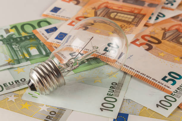 istock A light bulb lies on a table covered with euro banknotes on a light background close-up 2148044222