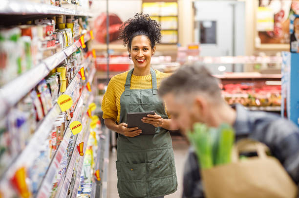 istock Smiling Shopping Assistant in Grocery Aisle 2148044572