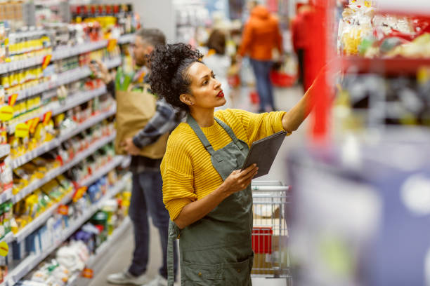 istock Professional Hispanic Shopping Assistant in Supermarket 2148044599
