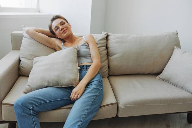 istock A woman wearing eyeglasses sits on a couch and looks at the camera. Vision problems 2148045080