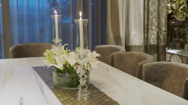 Luxurious Dining Table Setup With White Lilies And Candles In Glass Candelabra. closeup shot
