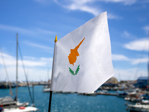 Cypriot national flag fluttering in the wind at sea harbor