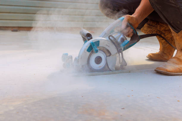 istock Construction worker uses a cutting machine grinder to cut concrete foundation after it has been poured 2148048416